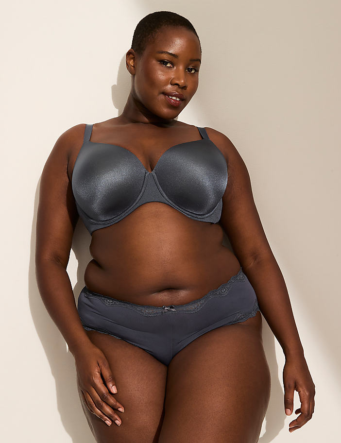 A person's lower body is shown from behind, wearing grey lace-trimmed underwear with the words "Good at being Bad" written on the back, against a plain, light-colored background.
