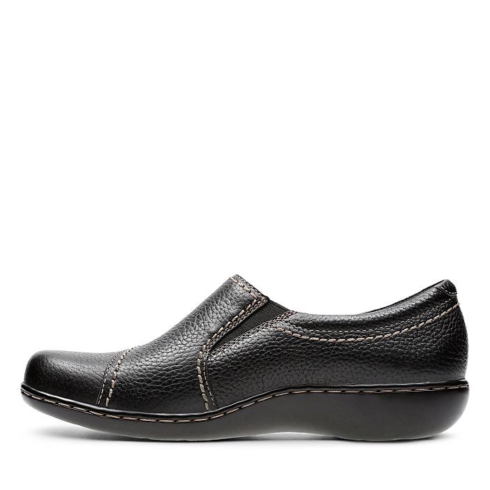 A single black leather slip-on shoe sits in the foreground against a plain white background.
