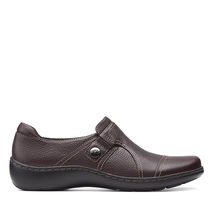 A single brown leather slip-on shoe sits in the foreground against a plain white background.