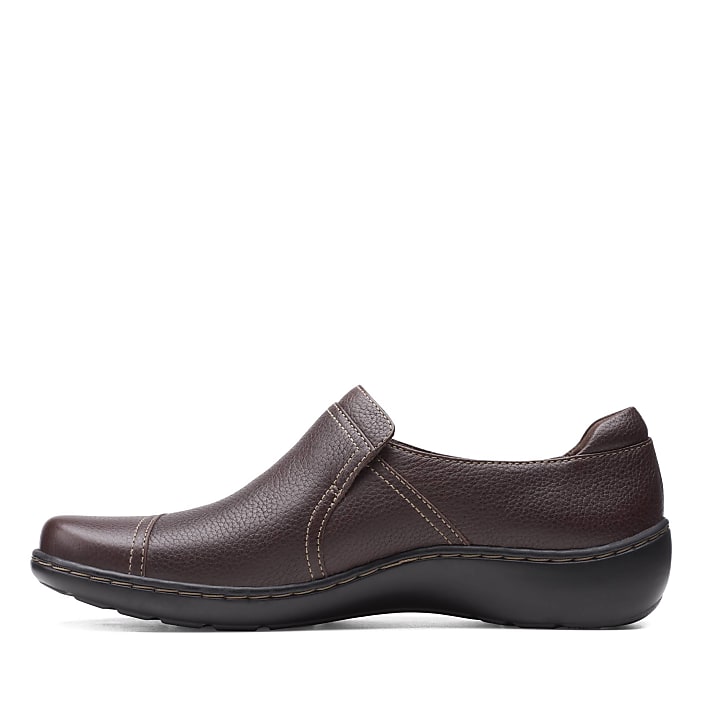A single brown leather slip-on shoe sits in the foreground against a plain white background.