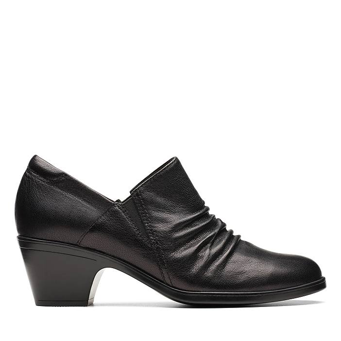 A black leather low-heeled shoe with a ruched front sits against a plain white background.