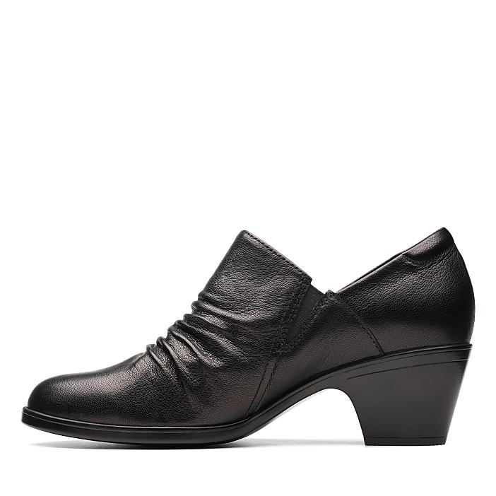 A black leather heeled shoe with a ruched front sits against a plain white background.