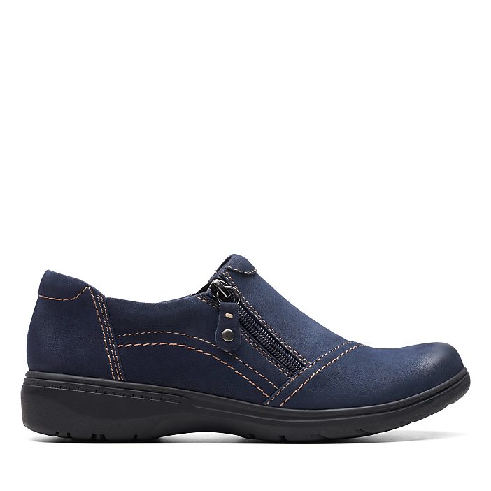 A single navy blue suede shoe with a zipper sits in the foreground against a plain white background.
