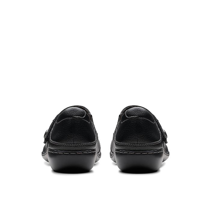 A pair of black leather loafers are positioned in the foreground against a plain white background.