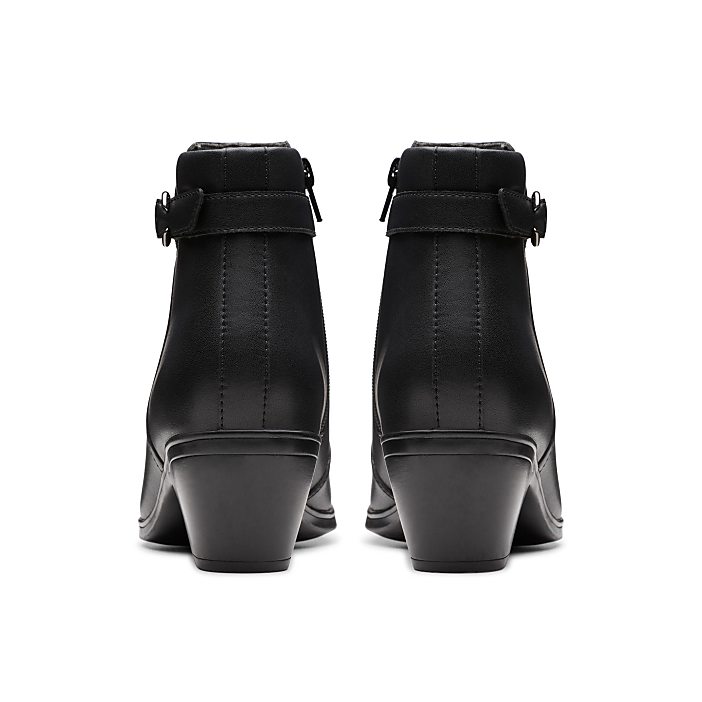 A black leather kitten heel boot with a zipper closure stands on a white background.