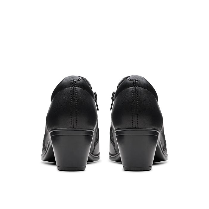 A pair of black heeled shoes is positioned in the foreground against a plain white background.