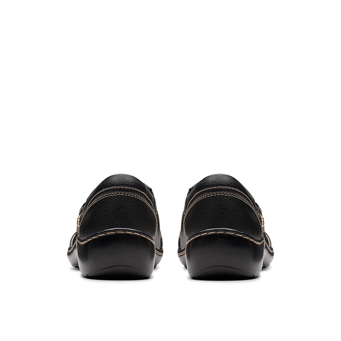 A pair of black leather loafers with tan stitching sits centered against a plain white background.