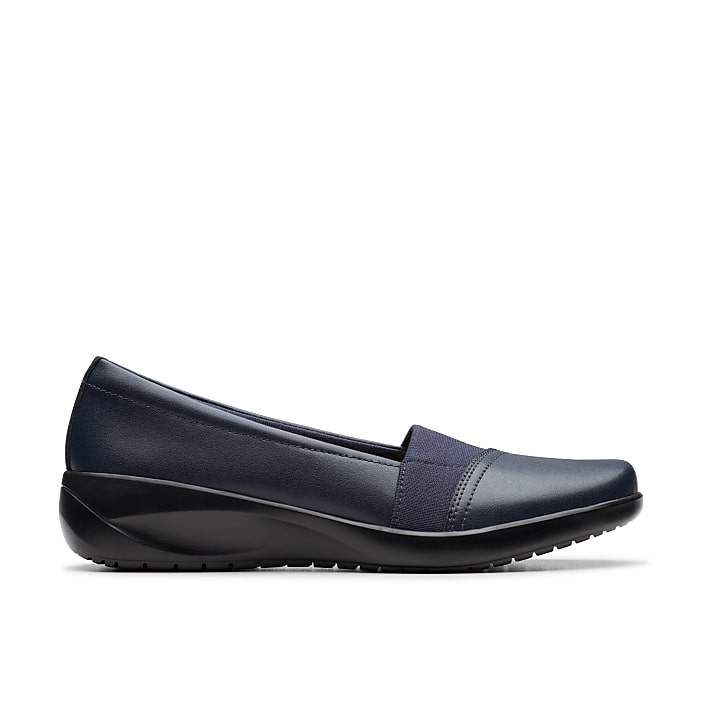 A navy blue slip-on shoe sits in the foreground against a plain white background.