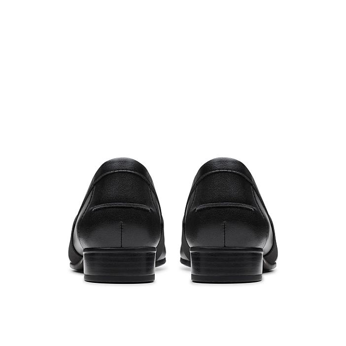 A pair of black leather loafers are positioned in the foreground against a plain white background.