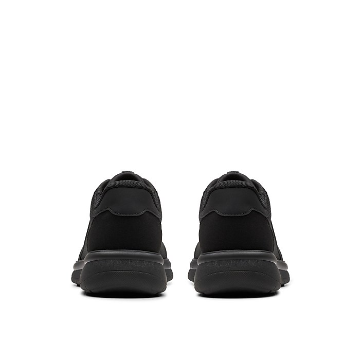 A pair of black sneakers is positioned in the foreground against a plain white background.