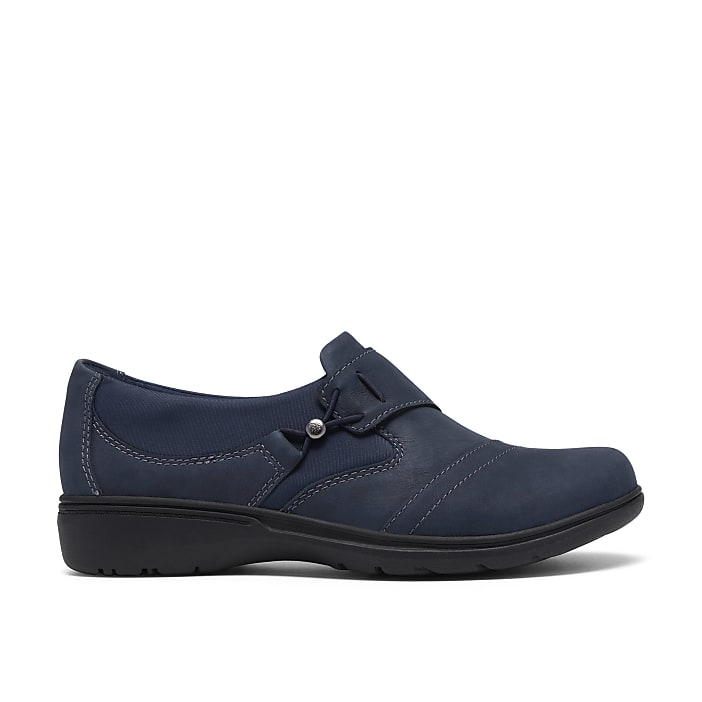 A single navy blue leather loafer sits in the foreground against a plain white background.