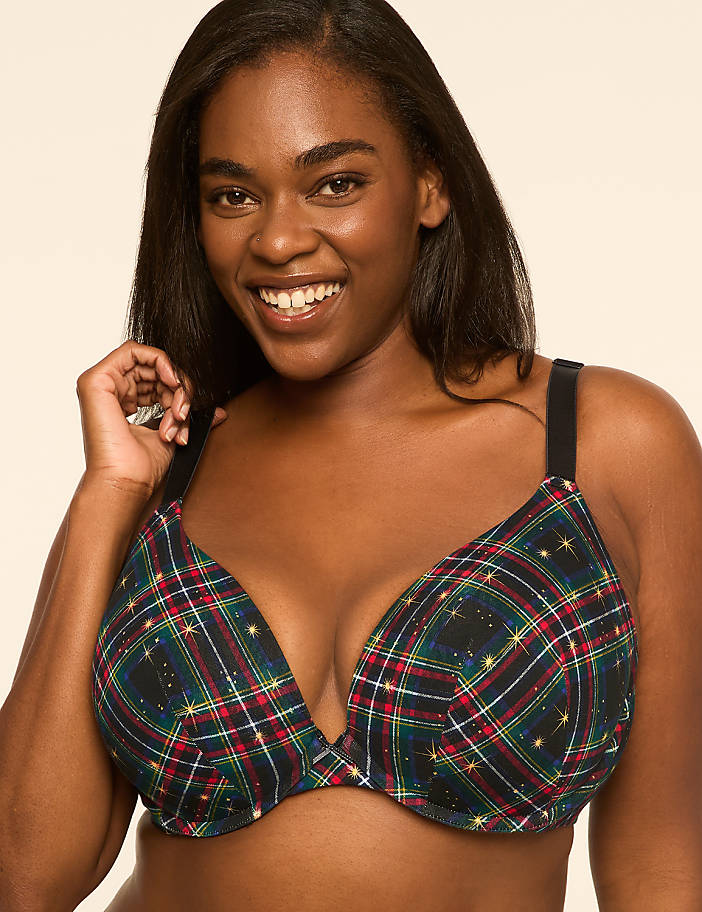 A smiling woman in a plaid bra with a subtle sparkle stands against a plain, light-colored background.