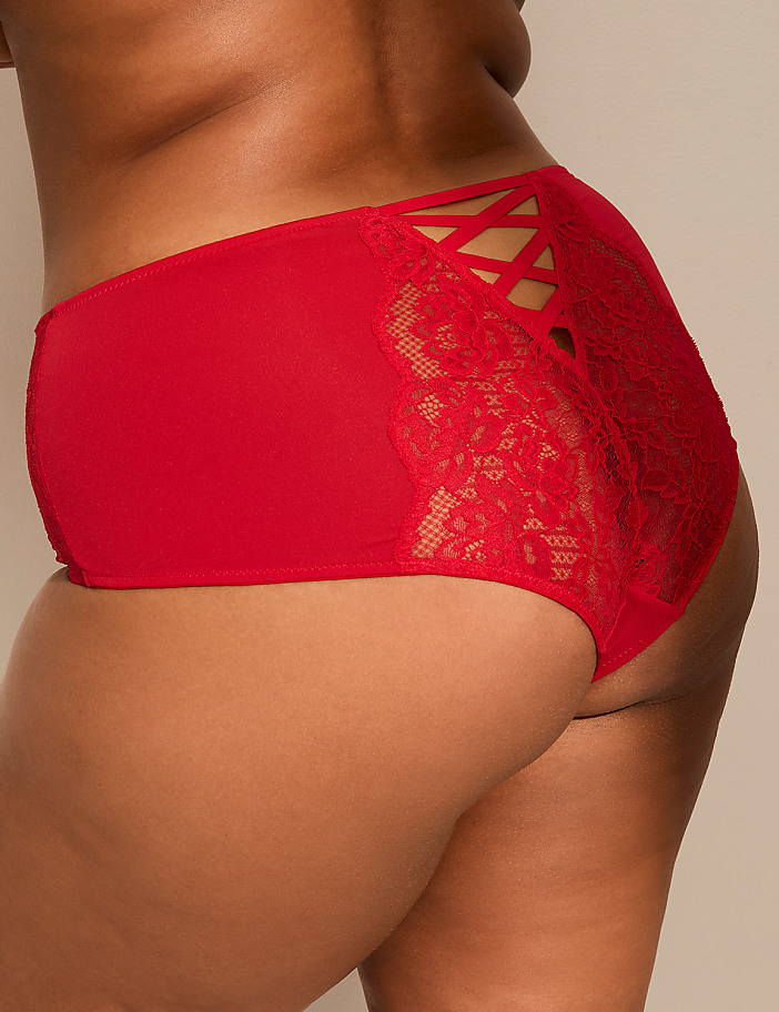 A person wears red lace-detailed underwear against a plain, neutral-toned background.