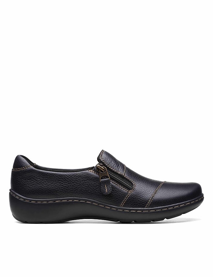A single black leather shoe with a side zipper sits in the foreground against a plain white background.