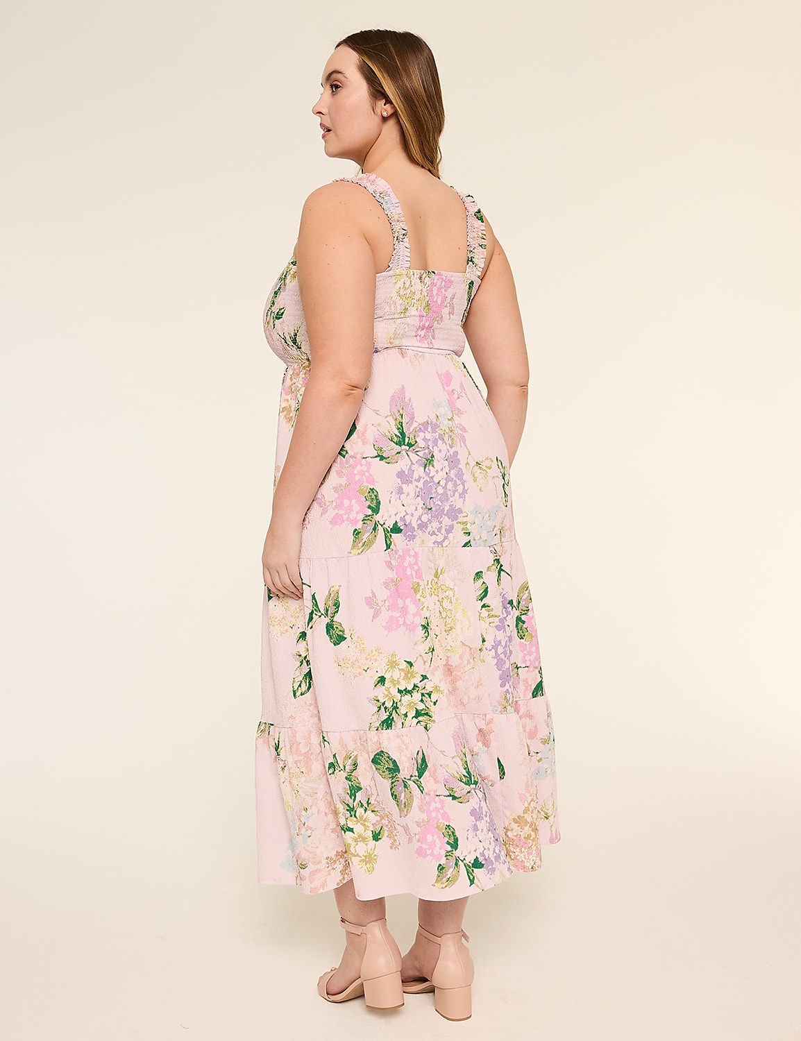 A woman wearing a floral print dress stands in a neutral-colored setting, her back facing the camera. Product Image 2
