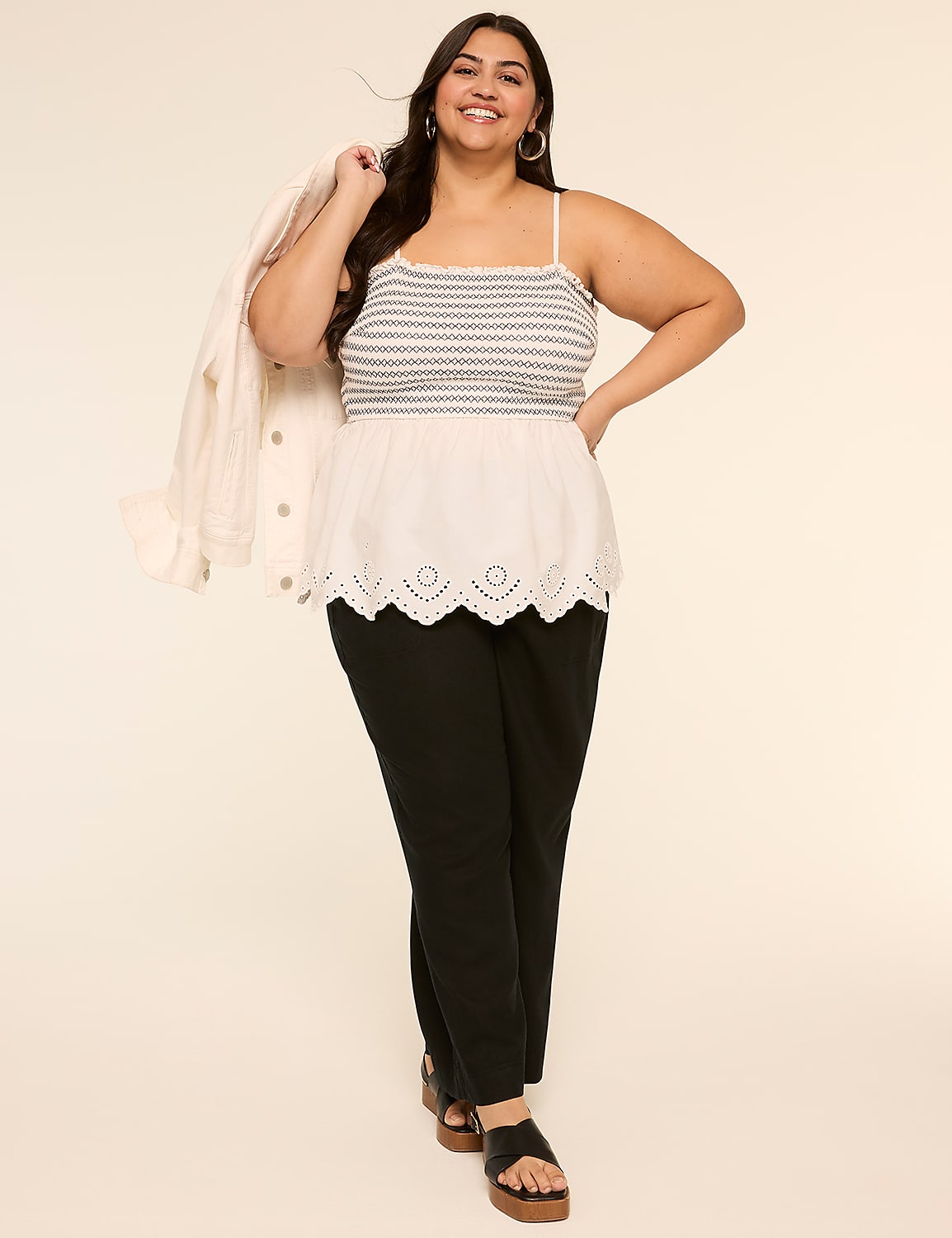 A smiling woman wearing a striped tank top and black pants stands against a plain beige background. Product Image 3