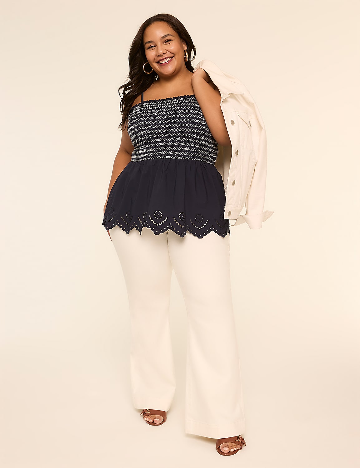A young woman with long dark hair is smiling and wearing a black and white striped top with a lace trim, paired with white pants and sandals, against a plain beige background. Product Image 3