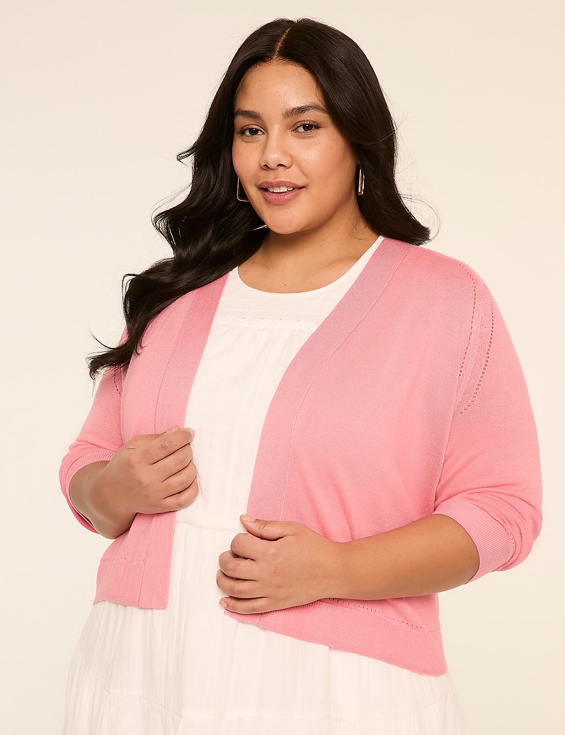 A young woman with long dark hair is wearing a pink cardigan and a white top, standing against a plain background. Product Image 1