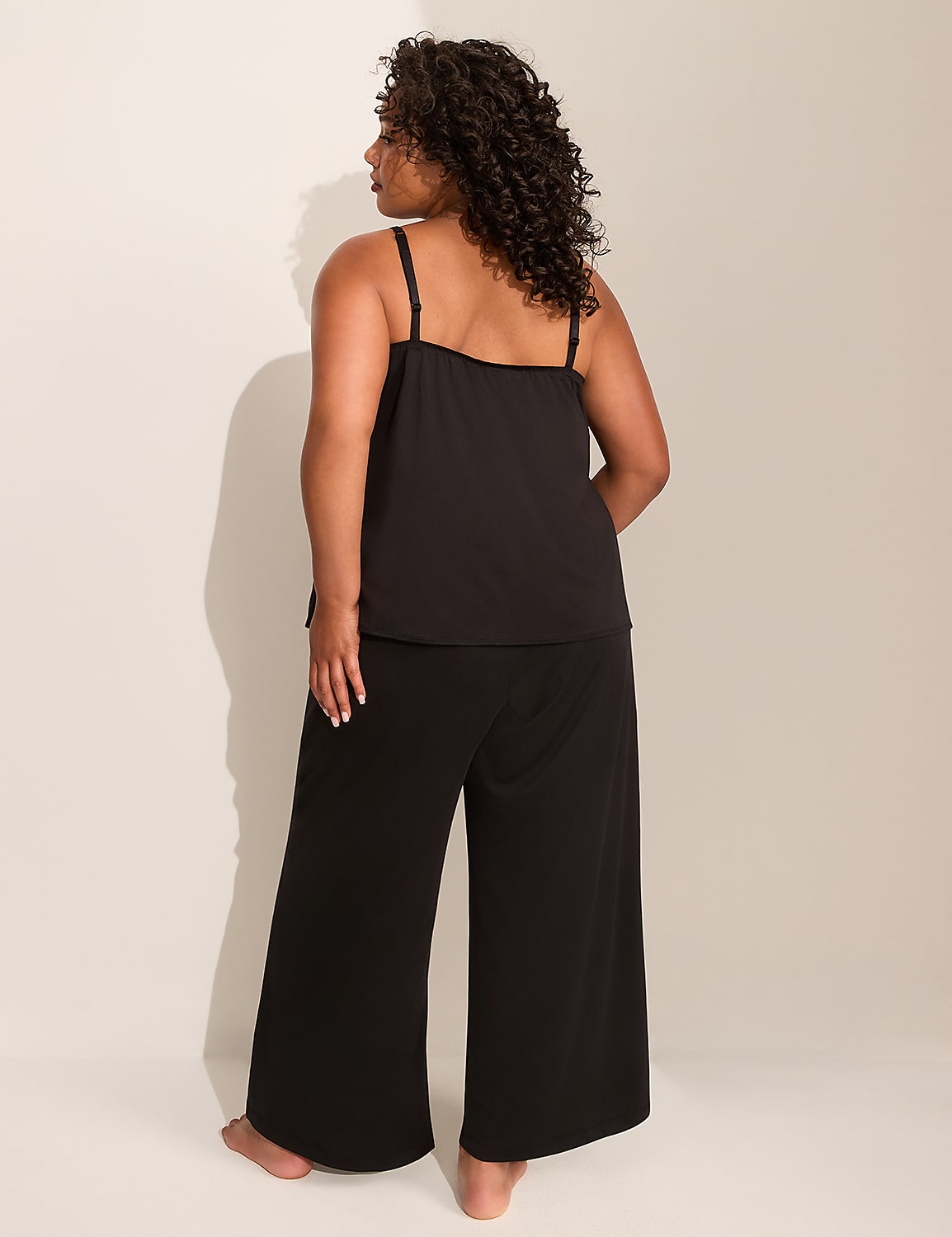 A woman in black pajamas stands with her back to the camera against a plain, light-colored background. Product Image 2