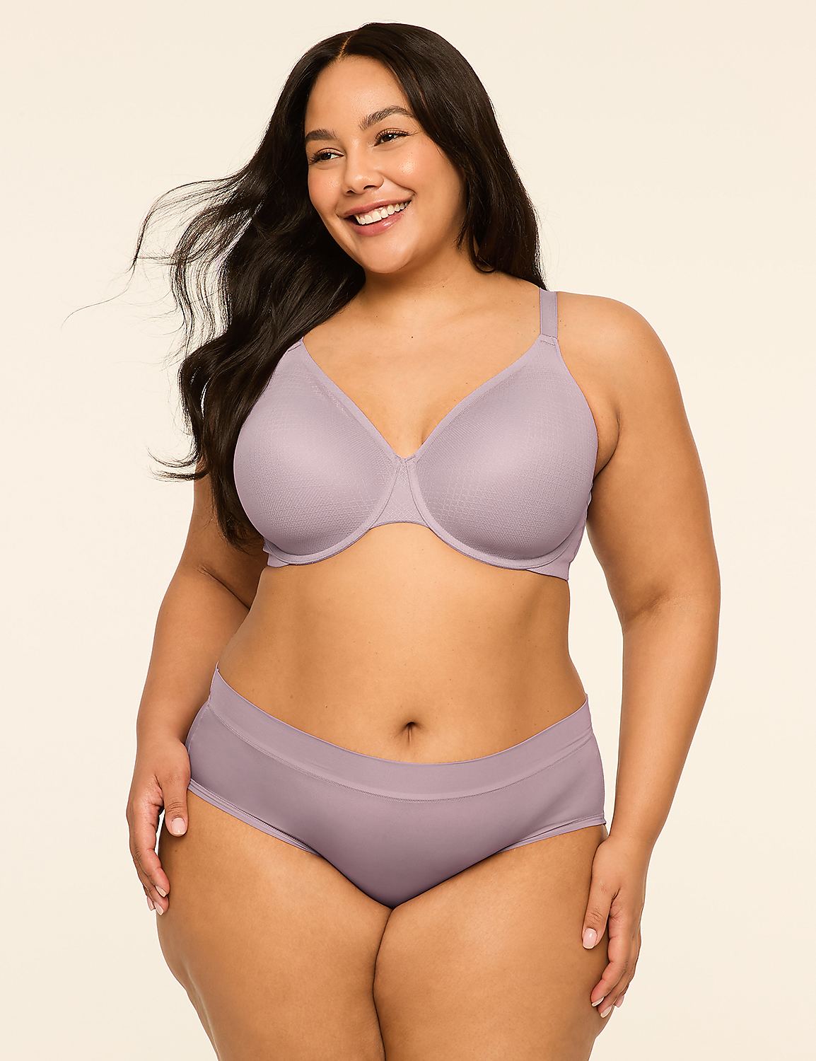 A smiling woman with dark hair stands in the foreground wearing a lavender bra and matching underwear against a plain, light-colored background. Product Image 4