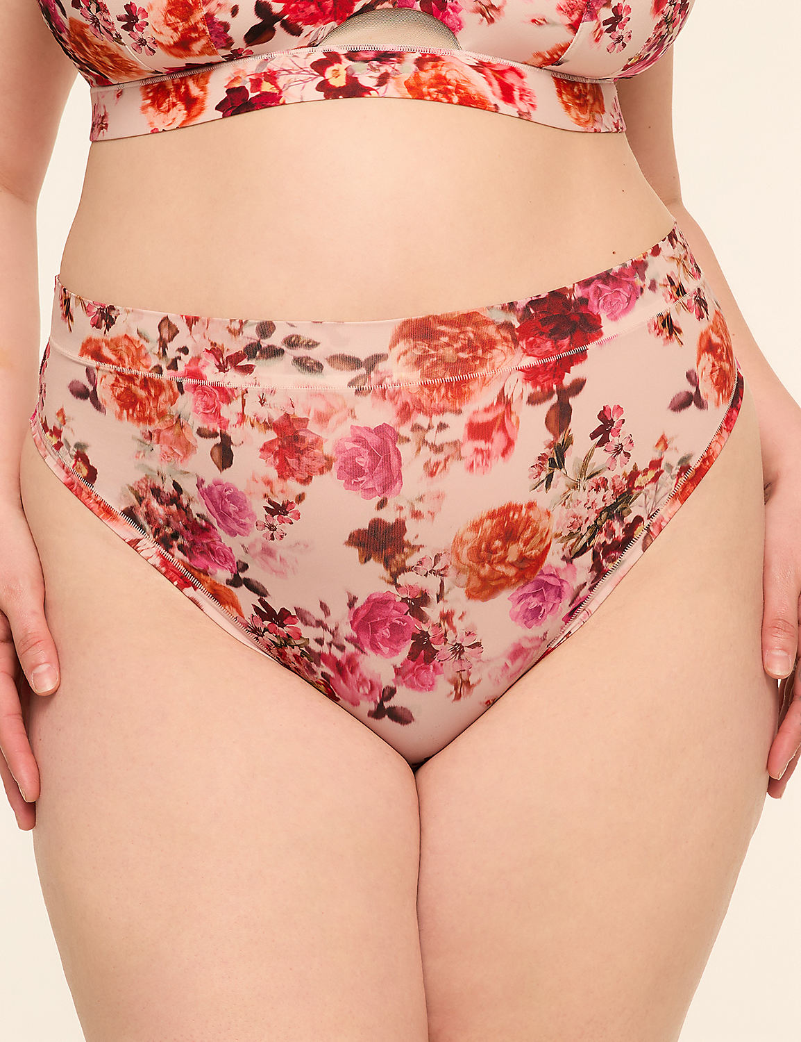 A person wears floral-patterned underwear in the foreground, against a plain, light-colored background. Product Image 1