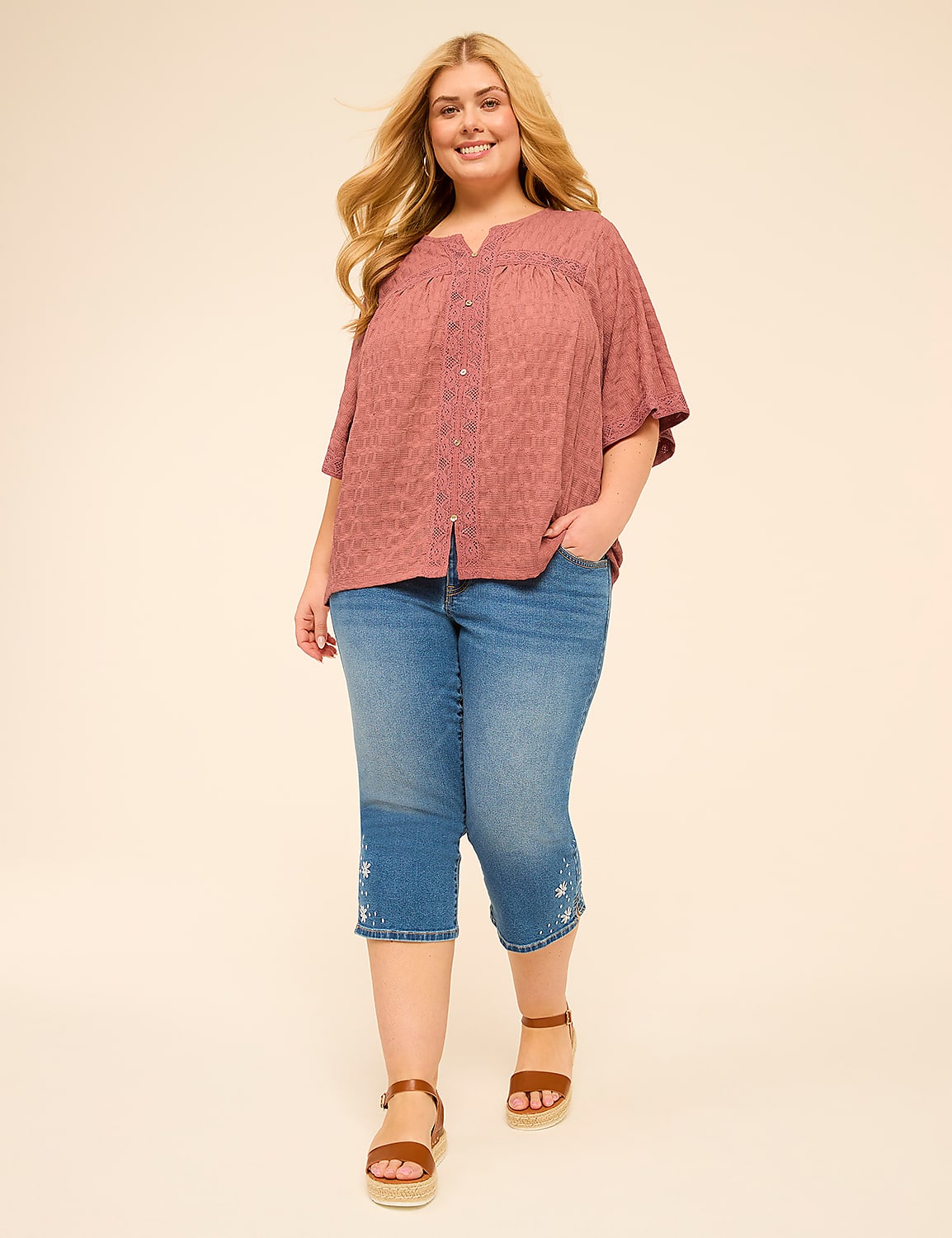 A smiling woman in a pink patterned blouse and embroidered capri jeans stands against a plain, light-colored background. Product Image 3