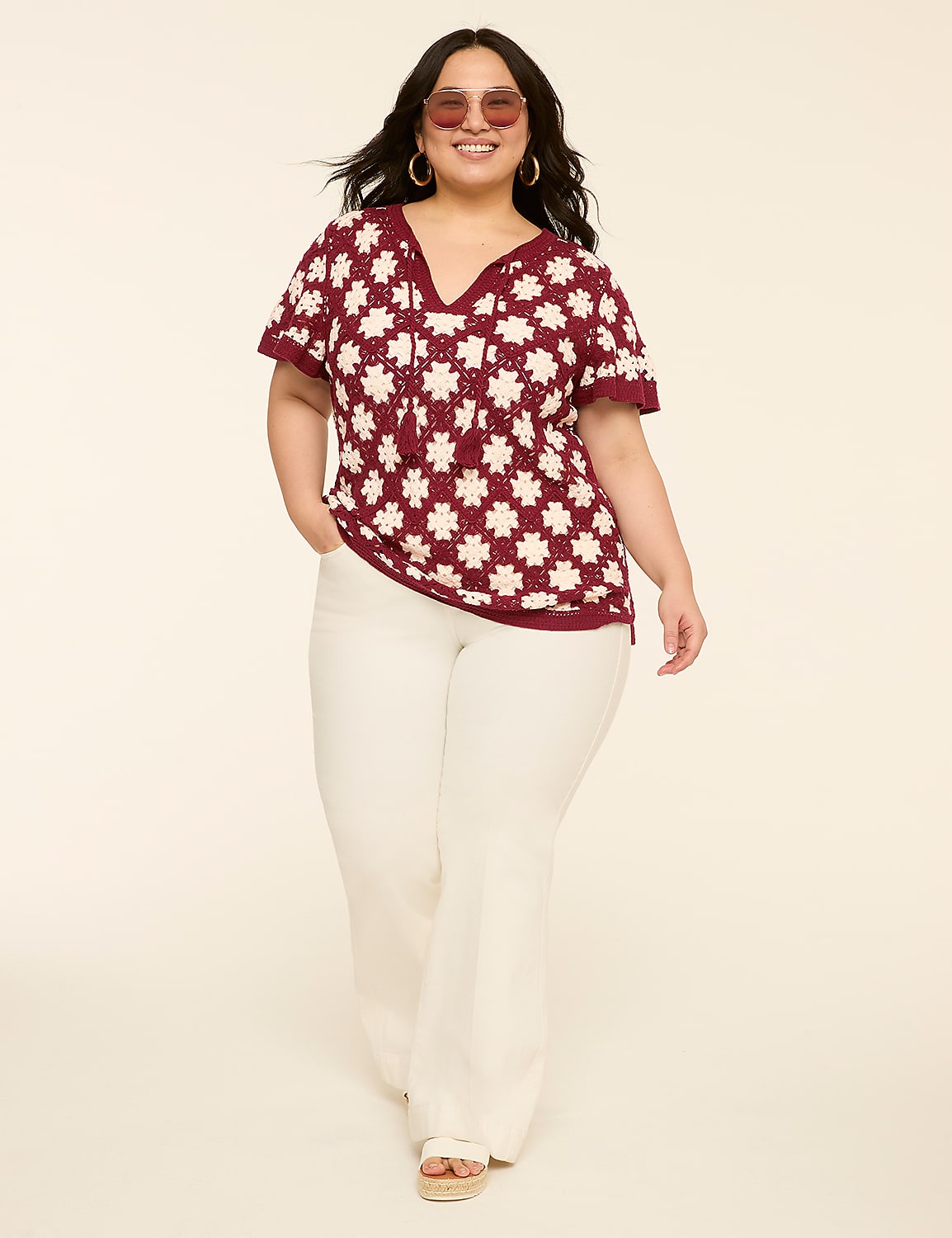 A woman in a maroon and white patterned top and white pants stands against a plain, light-colored background. Product Image 3