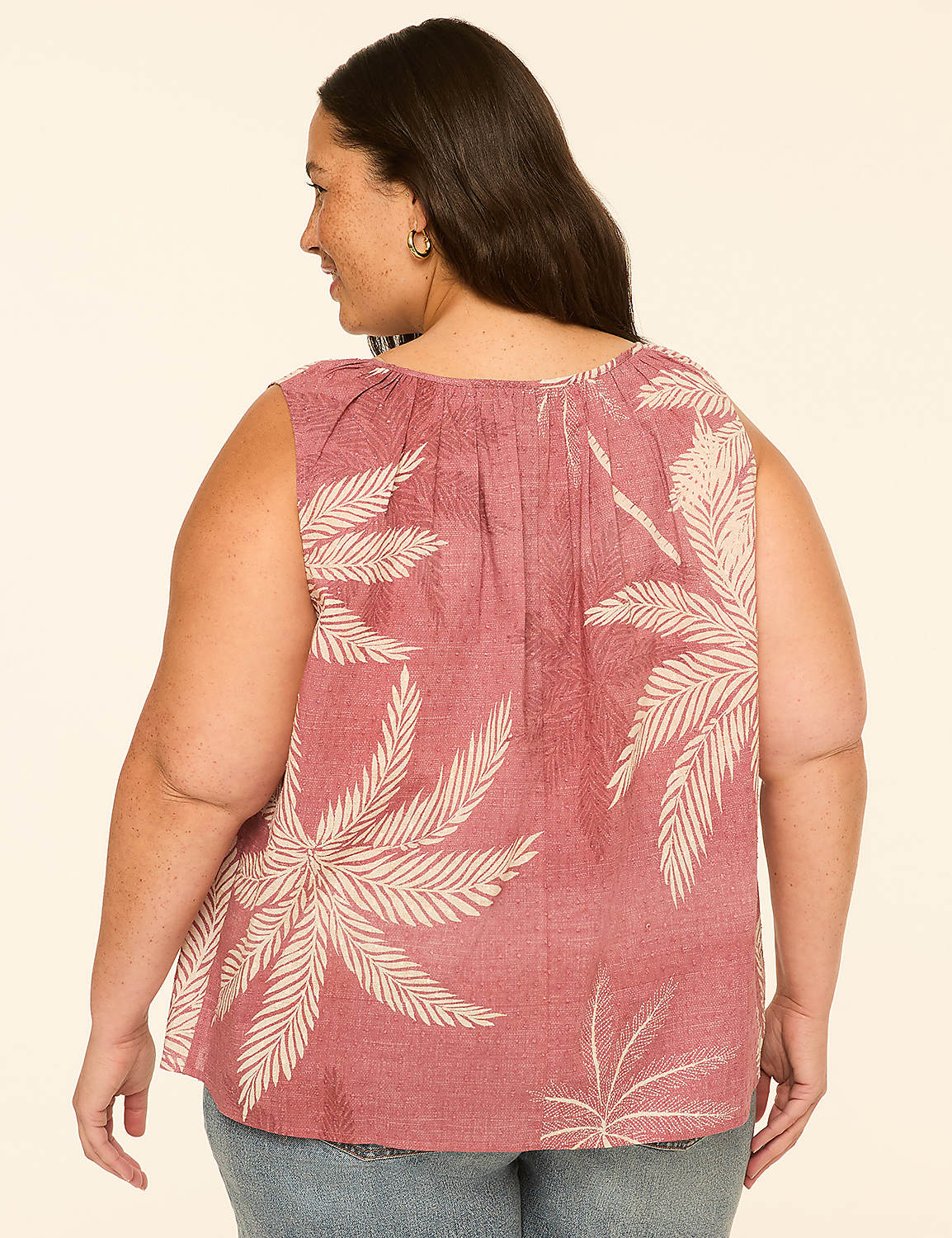 A woman in a pink palm-print top stands against a plain, light-colored background. Product Image 2