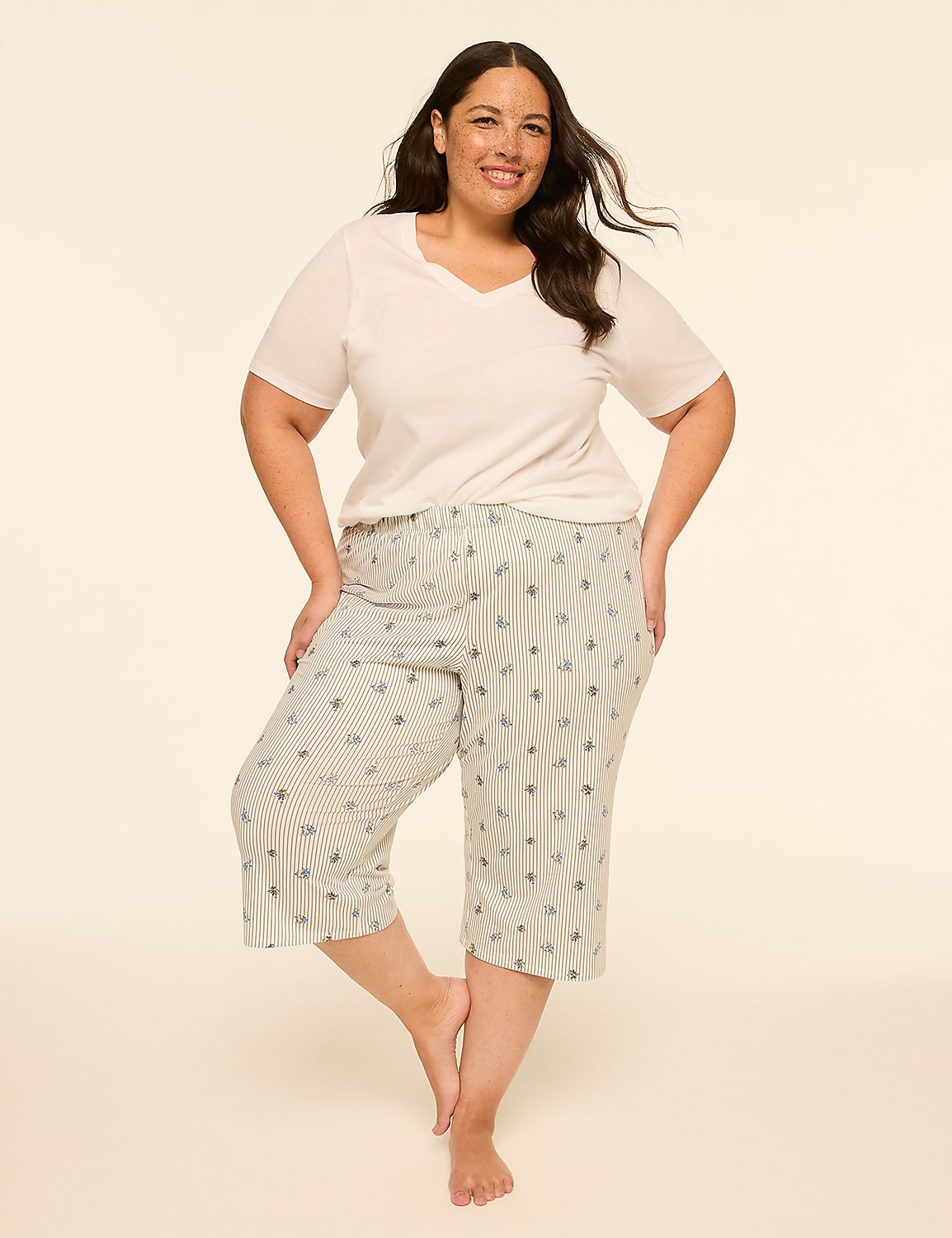 A smiling woman in a white v-neck shirt and patterned capri pajamas stands against a plain, light-colored background. Product Image 3