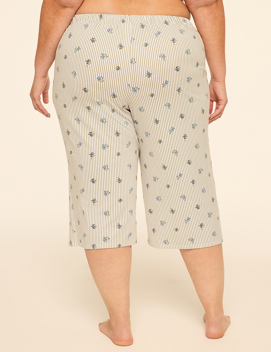 A person from behind wears striped capri pants with a floral pattern against a plain, light-colored background. Product Image 2