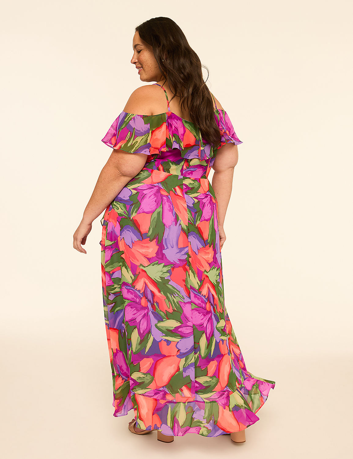 A woman in a vibrant floral off-the-shoulder maxi dress stands against a plain, light-colored background. Product Image 2