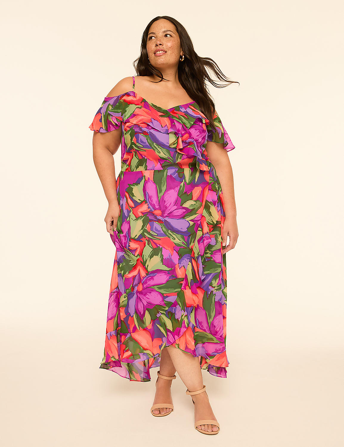 A woman in a vibrant floral cold-shoulder dress stands against a plain, light-colored background. Product Image 1