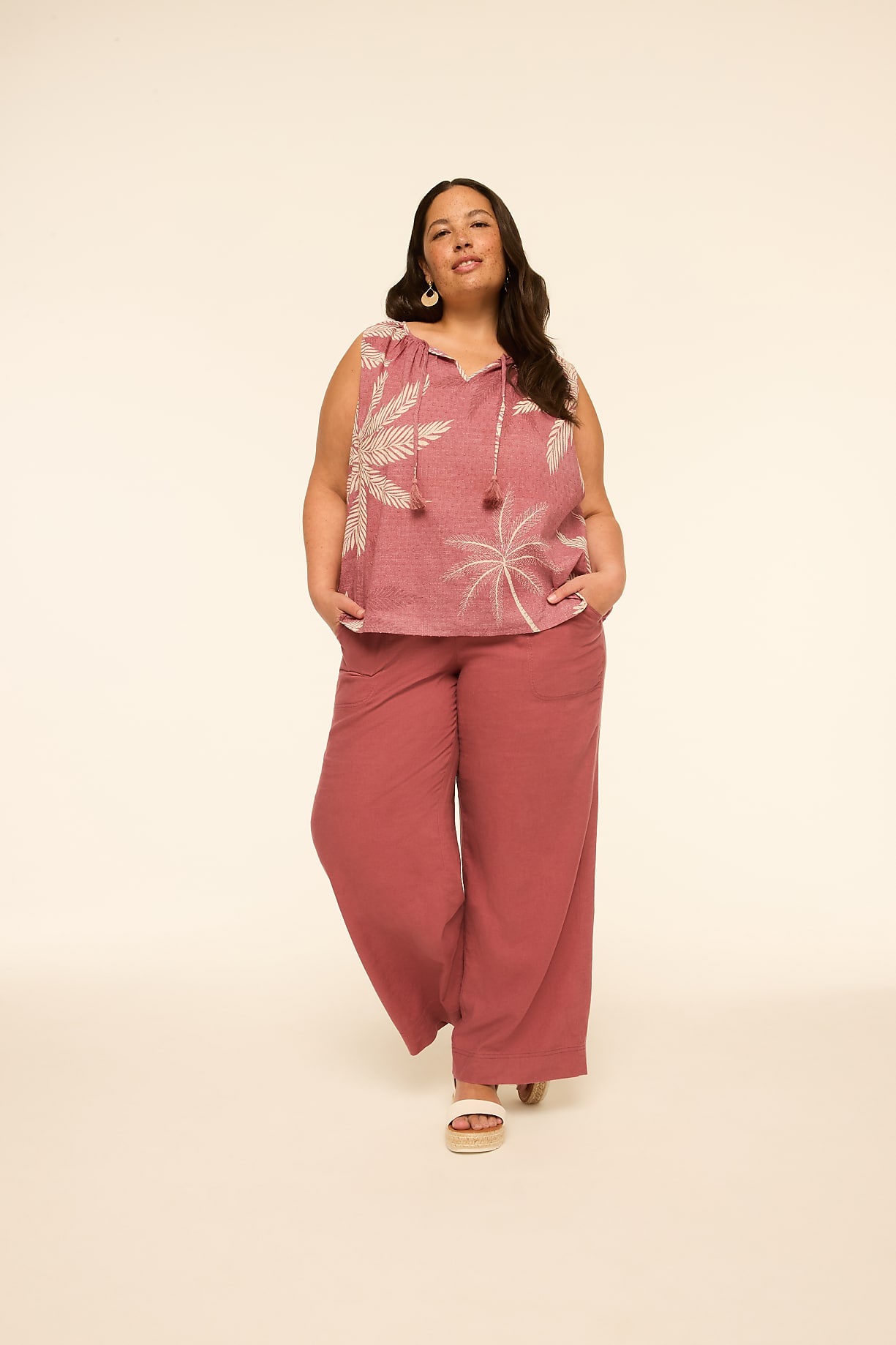 A woman in a pink floral top and wide-leg pants stands against a plain, light-colored background. Product Image 9