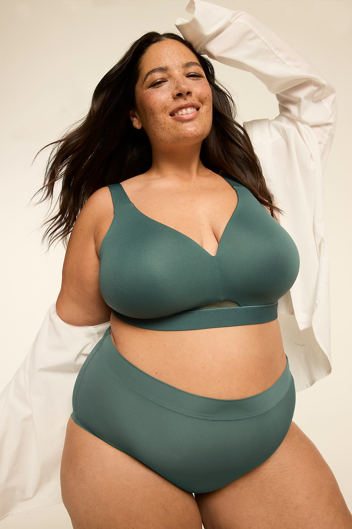 A woman in teal lingerie smiles as she poses against a plain, light background. Product Image 8