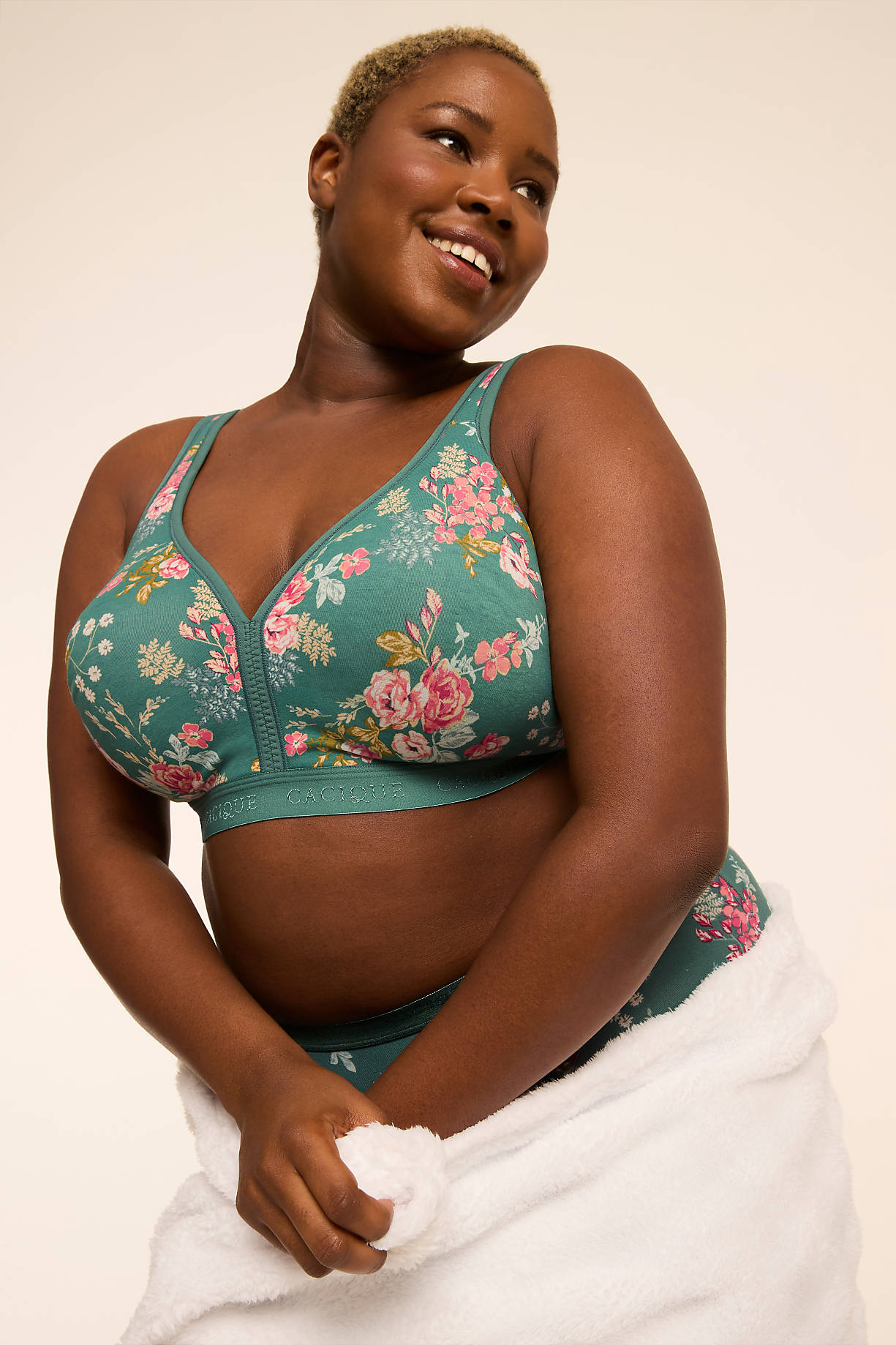 A smiling woman with short blonde hair poses in a floral bra and matching underwear, wrapped in a white towel against a plain background. Product Image 8
