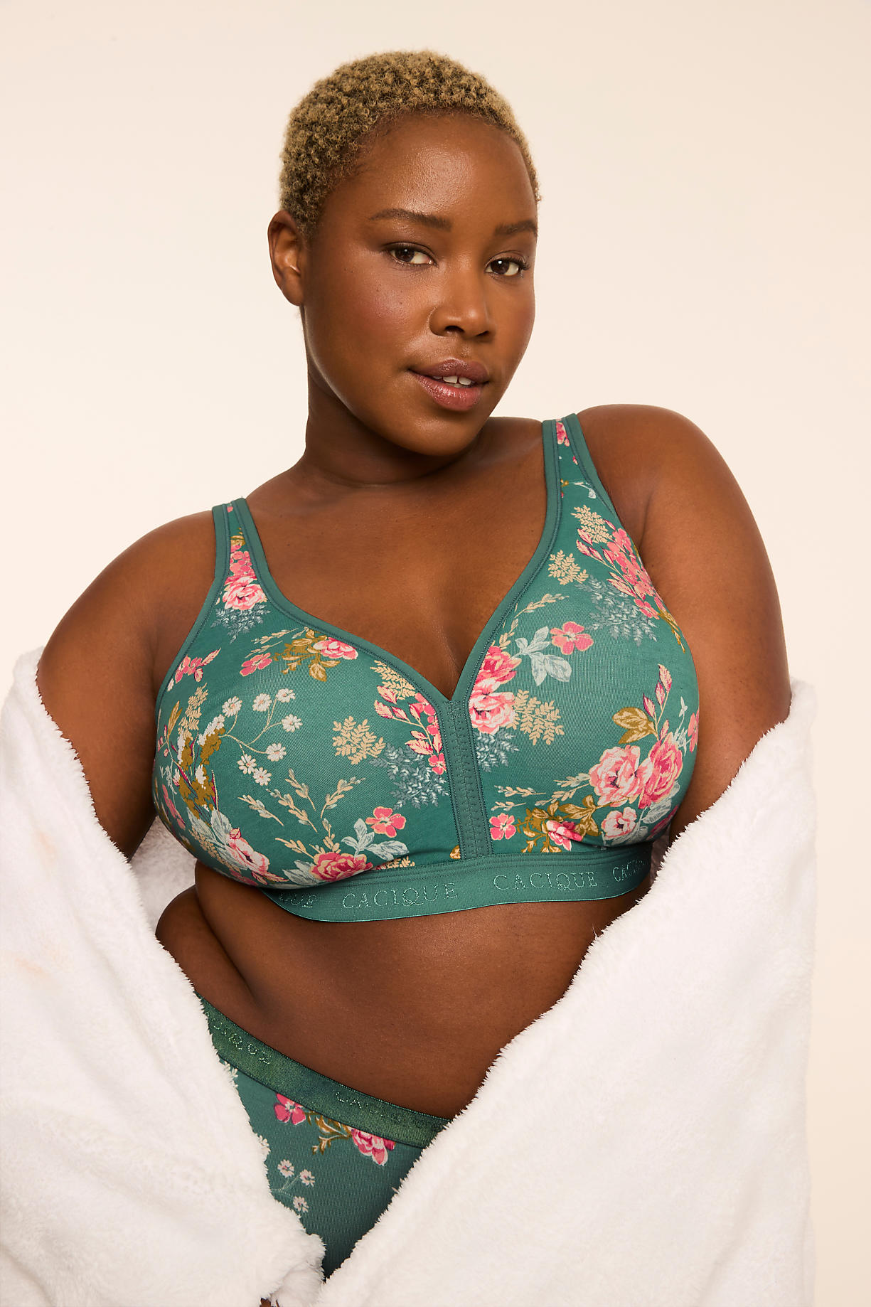 A woman with short blonde hair and a floral bra is wrapped in a white robe against a plain background. Product Image 10