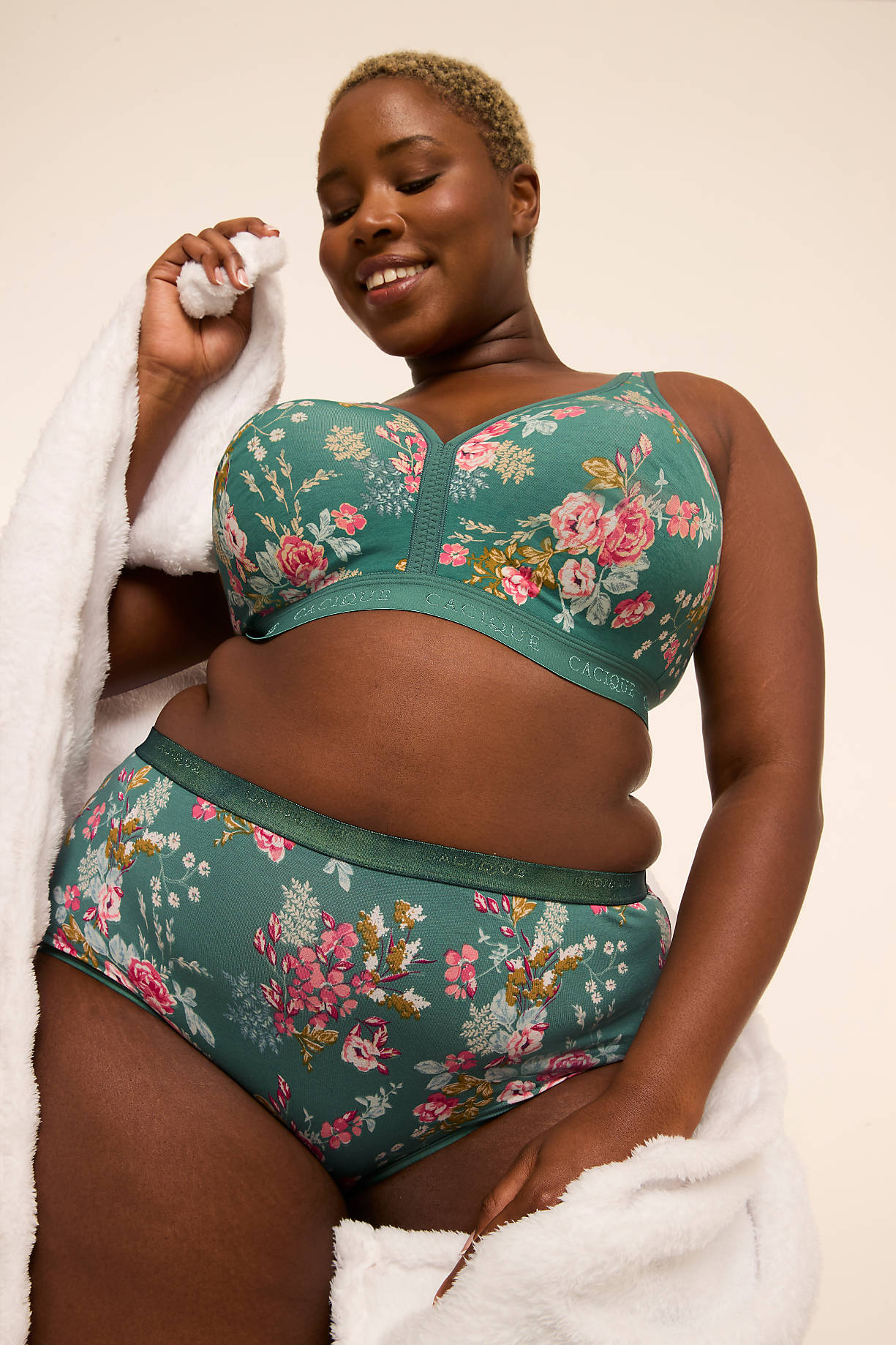 A smiling woman in floral lingerie stands draped in a white robe against a plain background. Product Image 11