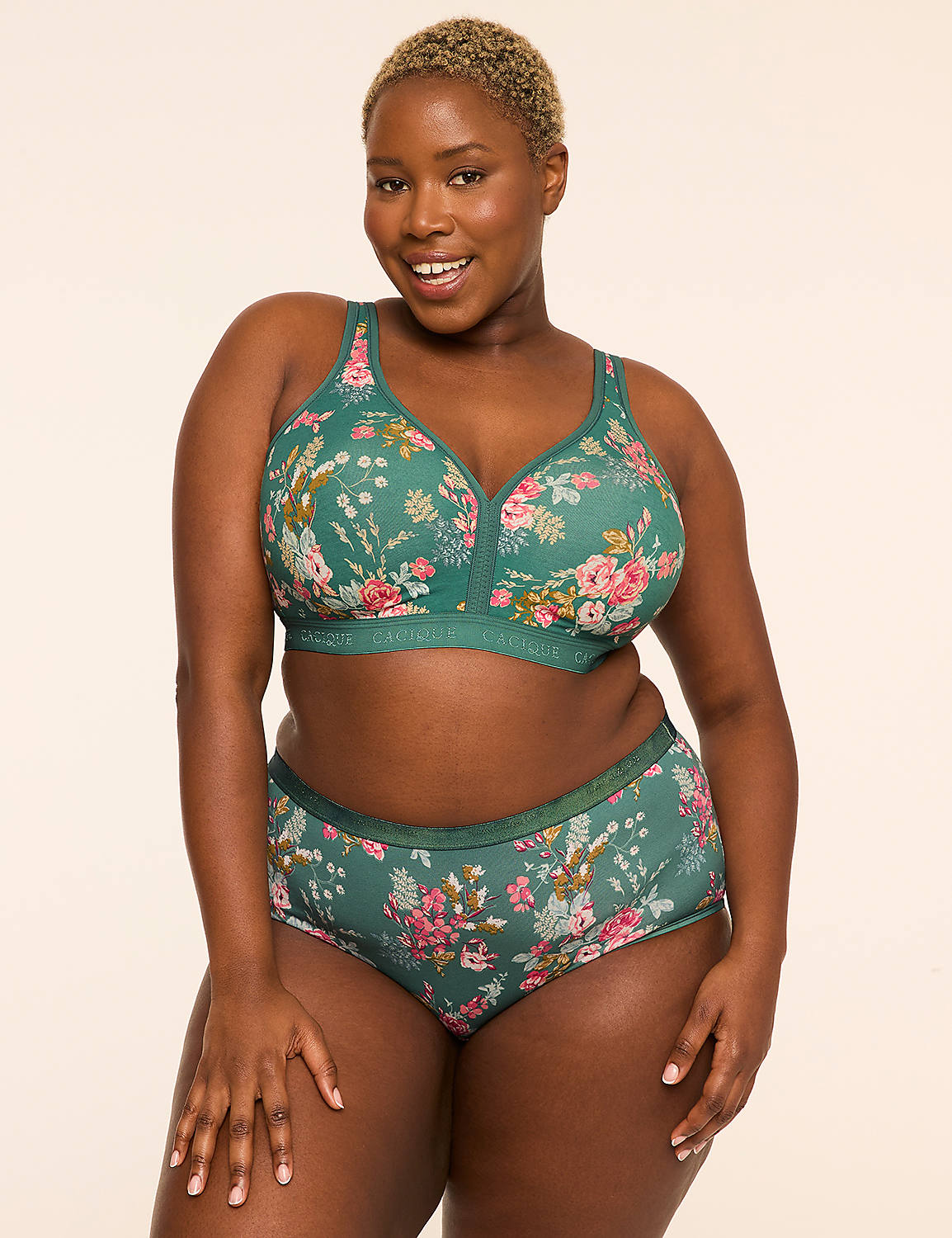 A smiling woman in a floral green bra and underwear stands against a plain, light-colored background. Product Image 4