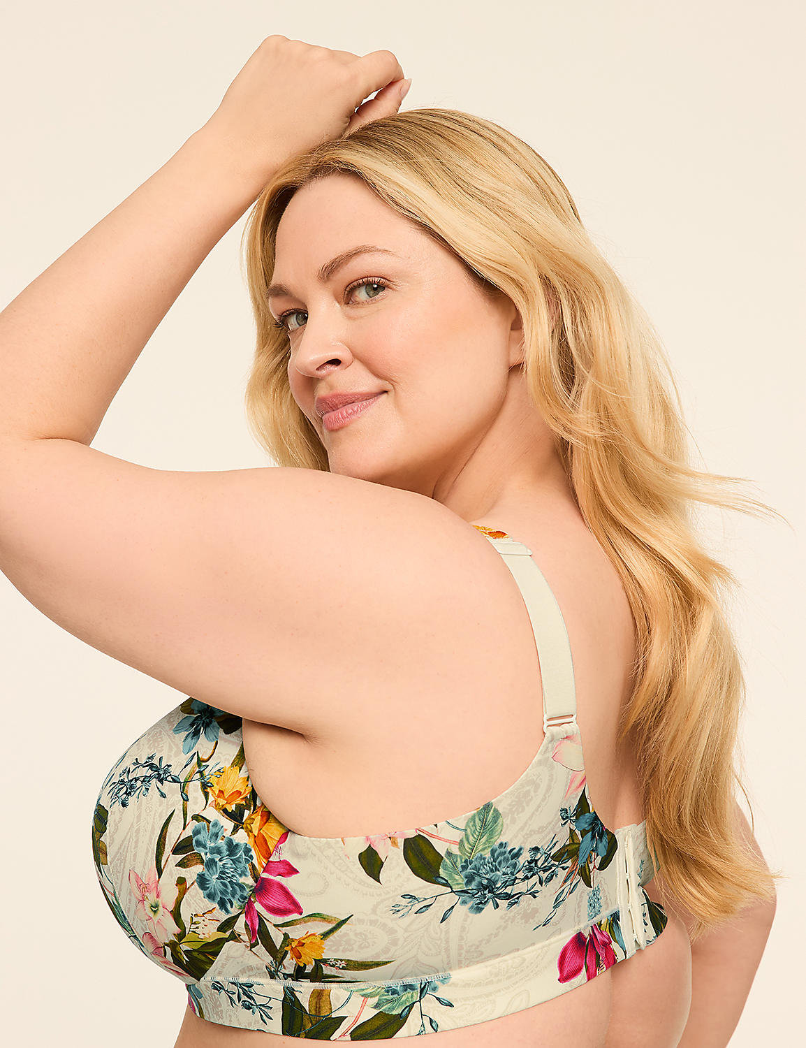 A blonde woman with a floral bra poses with her arm raised against a plain background. Product Image 3