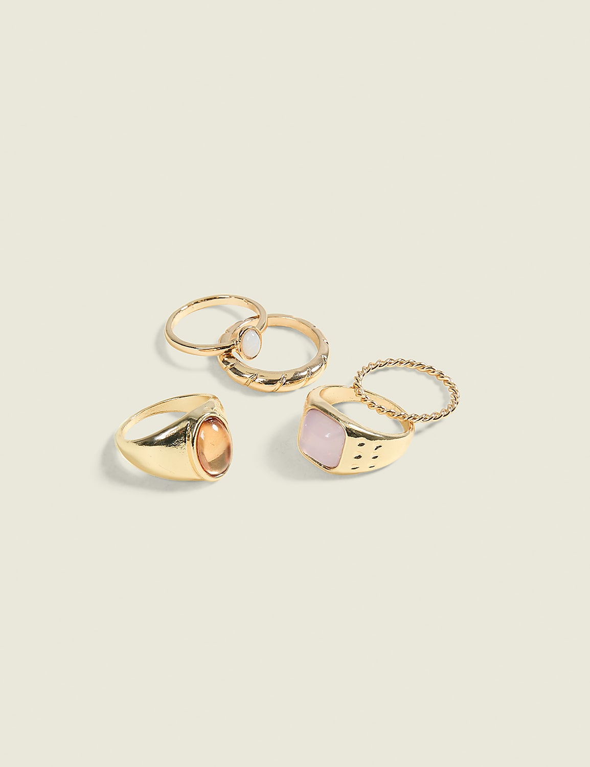 A collection of gold rings, some with gemstones, are arranged on a plain, light-colored background. Product Image 1