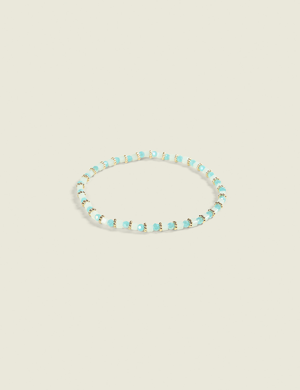 A delicate bracelet with small, light blue and white beads is centered against a soft, pale yellow background. Product Image 1