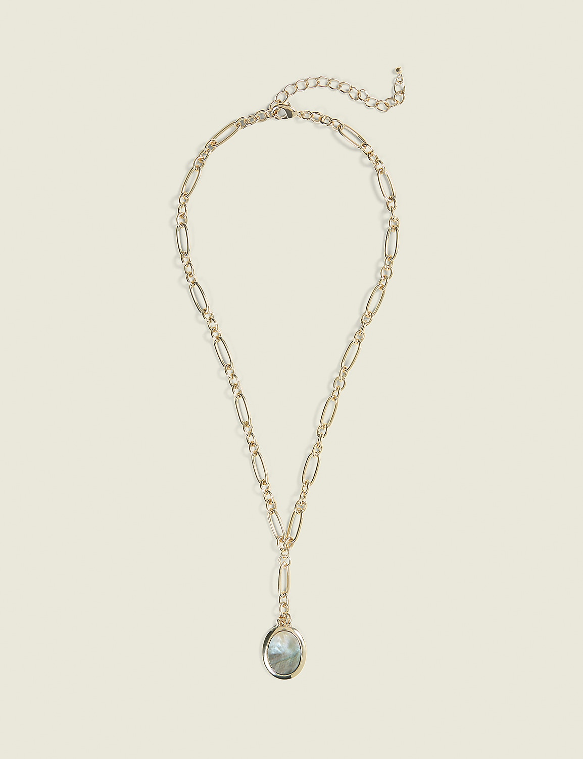 A gold necklace with an oval pendant hangs against a plain, light beige background. Product Image 1