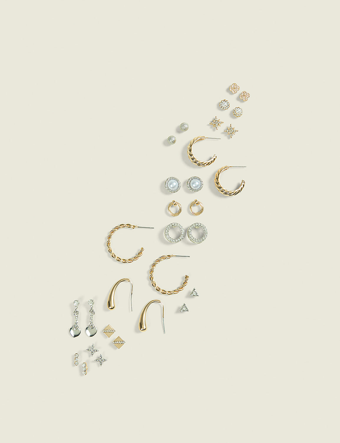 A collection of assorted earrings, including studs and hoops, are arranged diagonally on a plain, light-colored background. Product Image 1