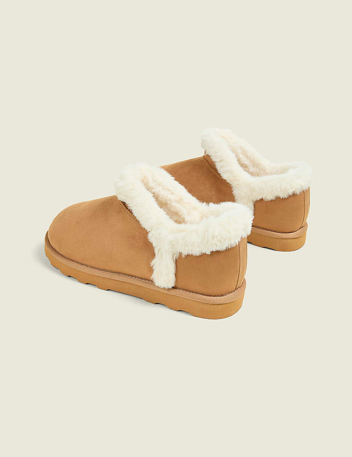 A pair of tan, fuzzy-lined slippers rests on a plain, light-colored background. Product Image 2