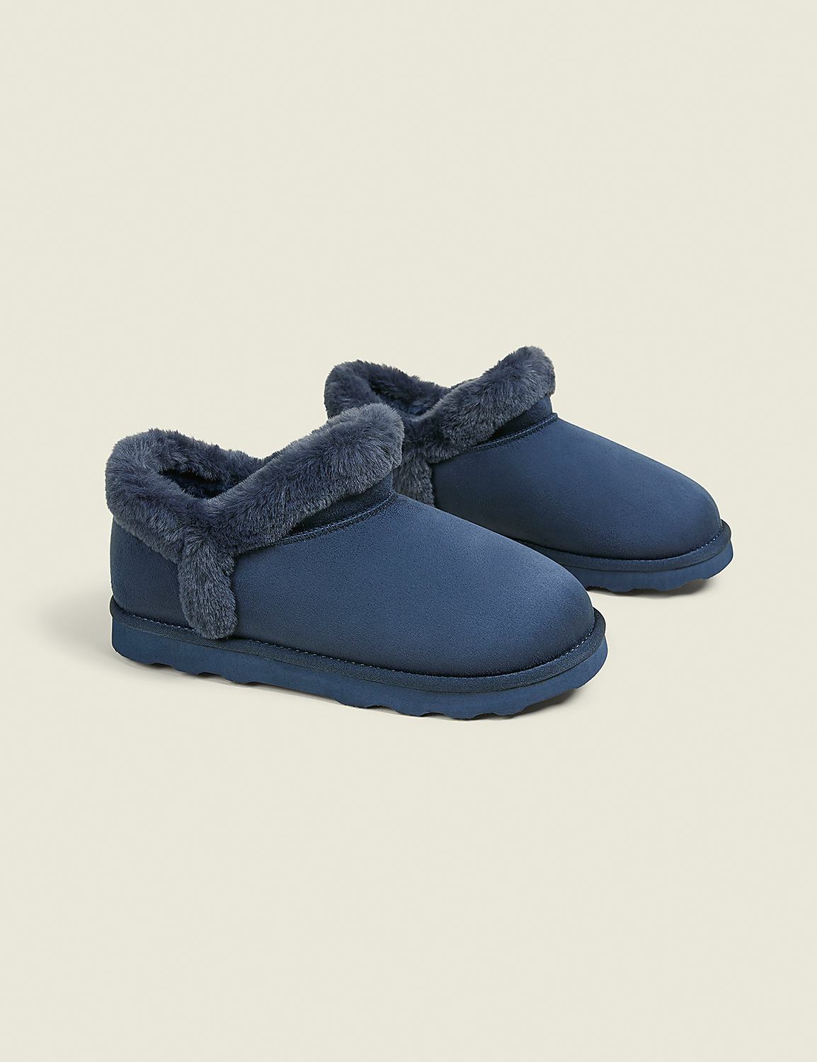 A pair of navy blue fur-lined slippers rests on a pale grey background. Product Image 1