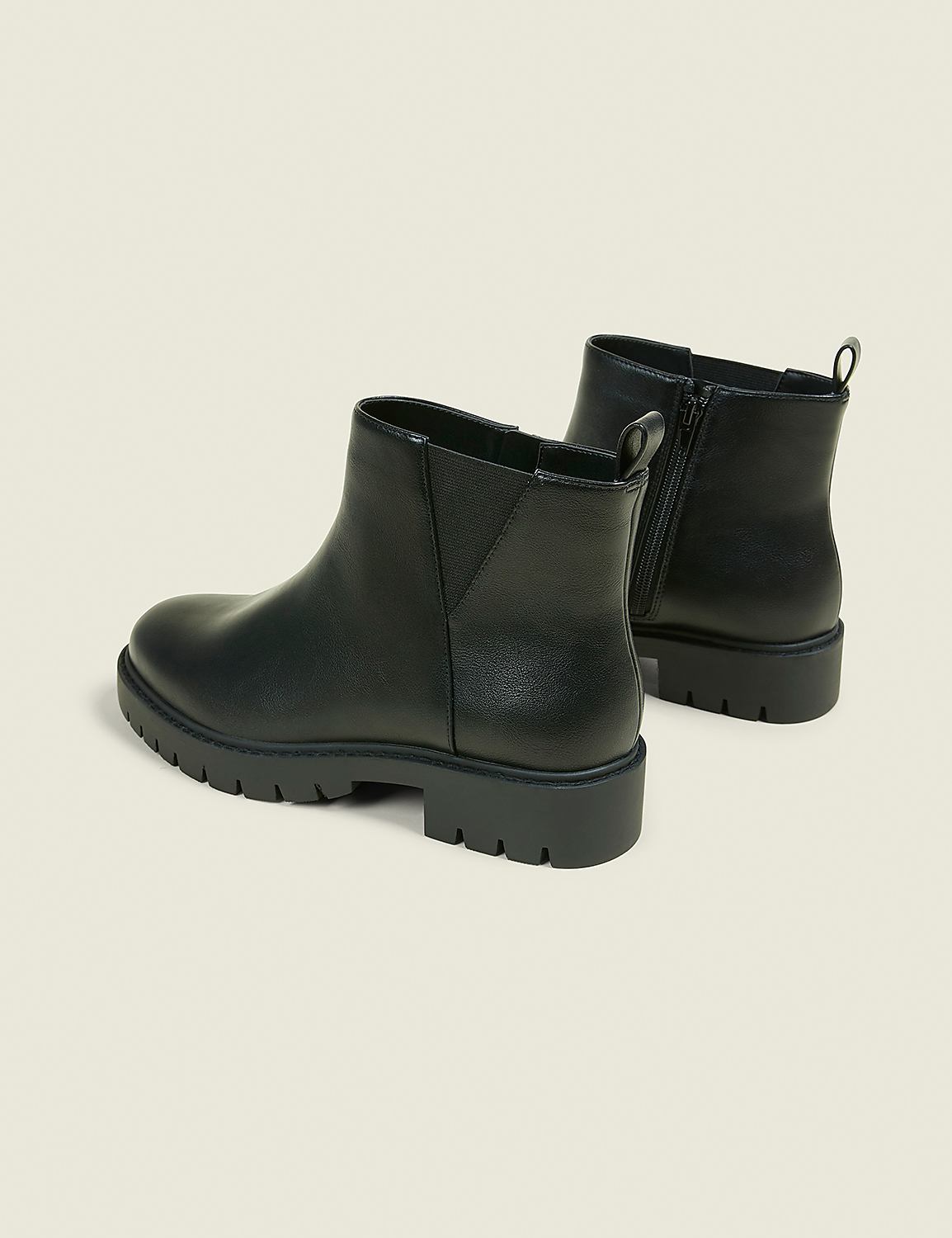 A pair of black leather Chelsea boots with thick soles are displayed against a plain, light-colored background. Product Image 2