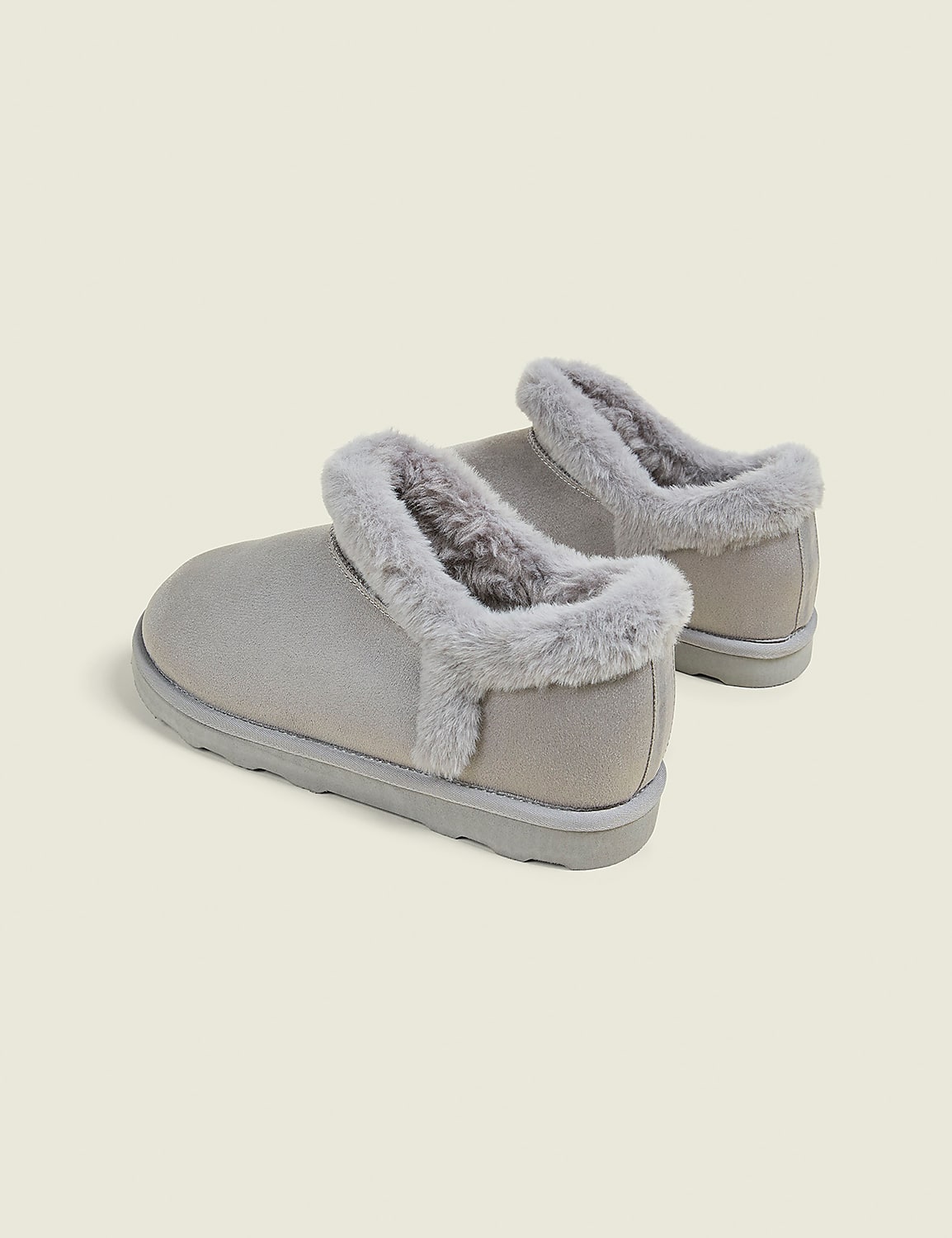 A pair of light gray, fuzzy-lined slippers rests on a pale gray background. Product Image 2