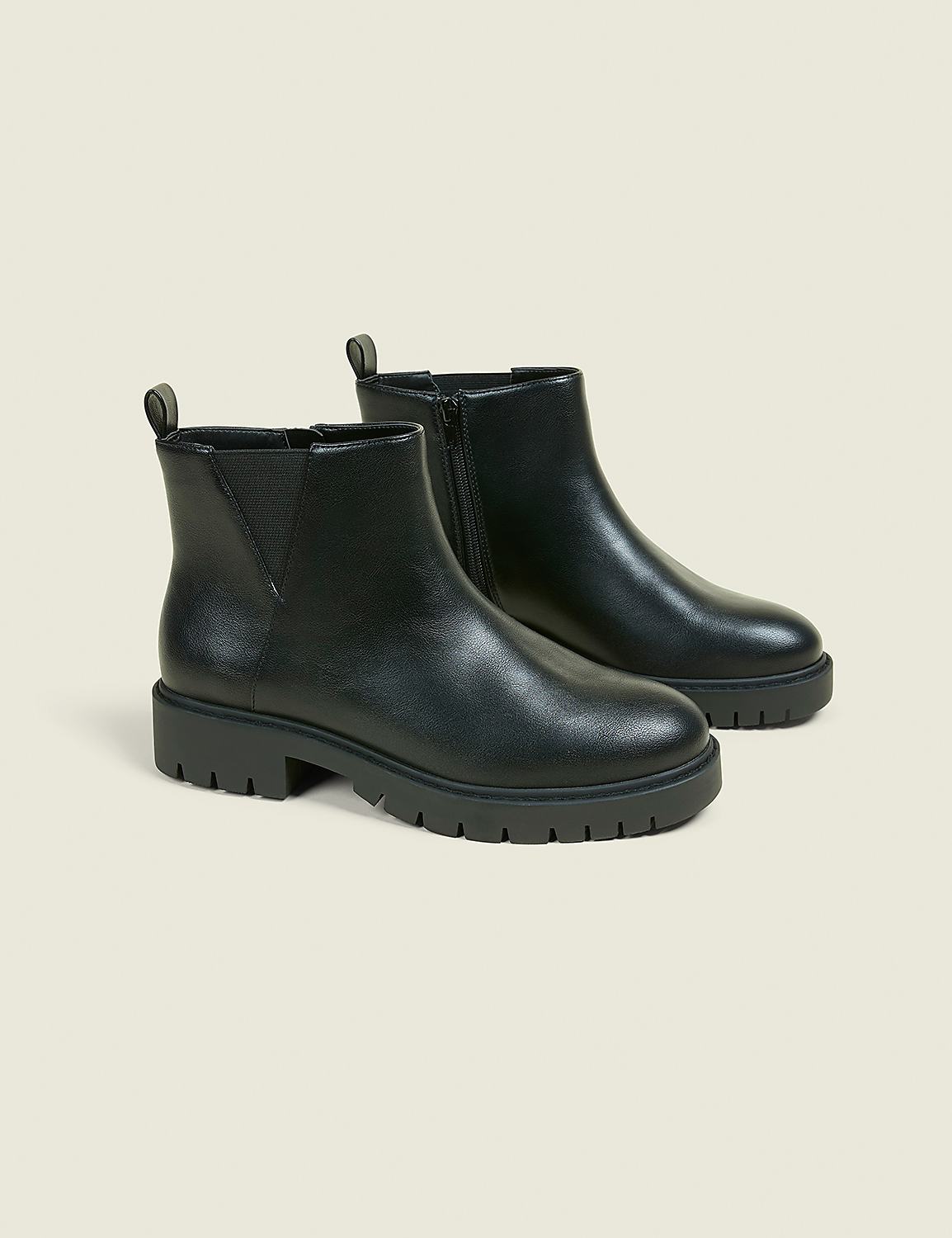 A pair of black Chelsea boots with thick soles are displayed against a plain, light-colored background. Product Image 1