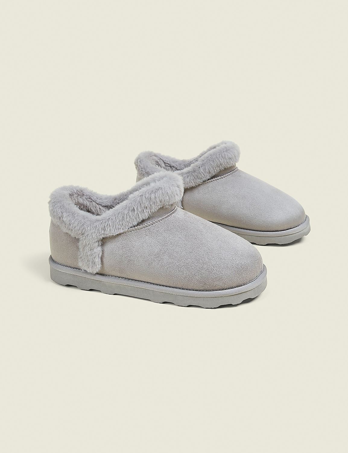 A pair of light gray, fuzzy-lined ankle boots rests on a plain, light gray background. Product Image 1