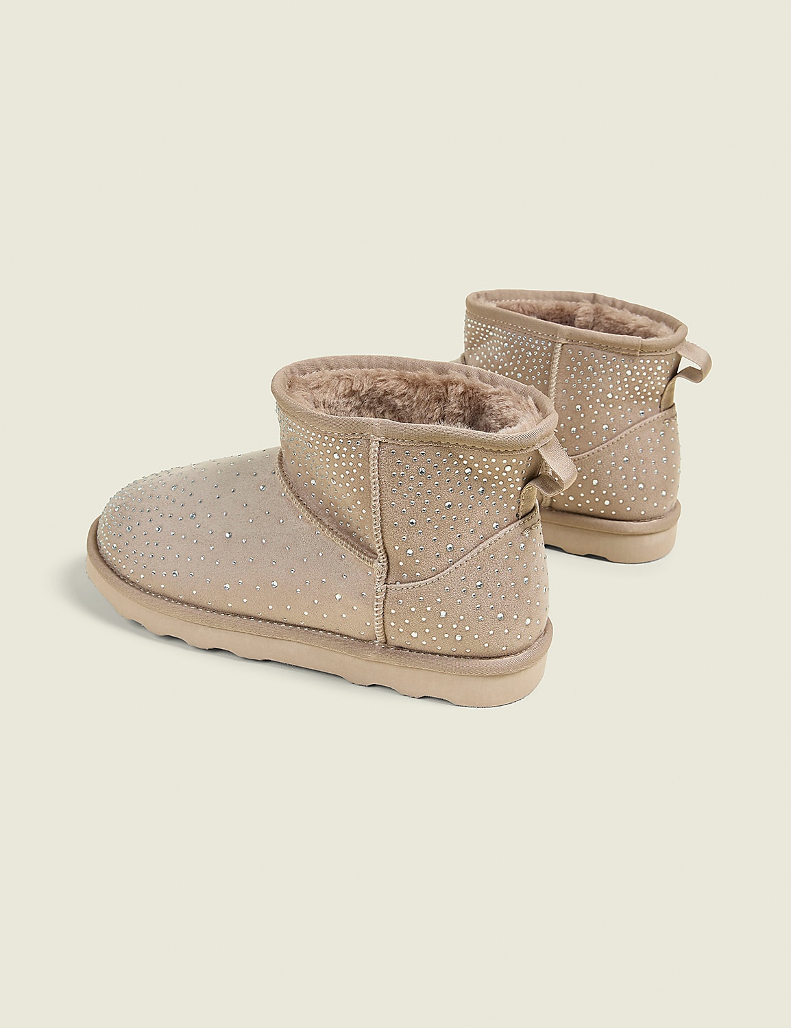 A pair of tan, rhinestone-embellished ankle boots with fluffy lining sit on a plain, light beige background. Product Image 2